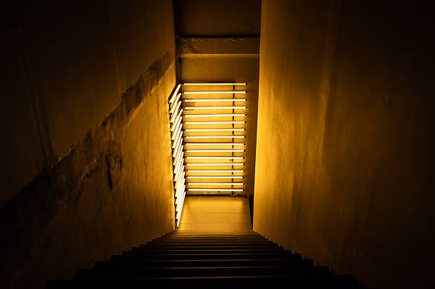 Staircase inside the dark old building decorated by bright yellow light at the corner.