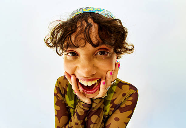 Young woman with curly hair showing joyful expression, embracing wellbeing at a studio