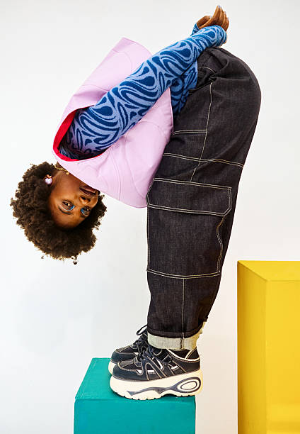 Young adult woman standing on colorful blocks wearing stylish gen z clothing