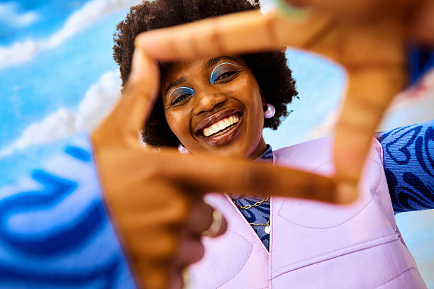 Young gen z woman smiling to camera in studio framing view with hands