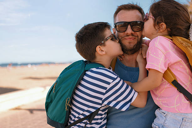 Happy dad posing with his kids during seaside vacation