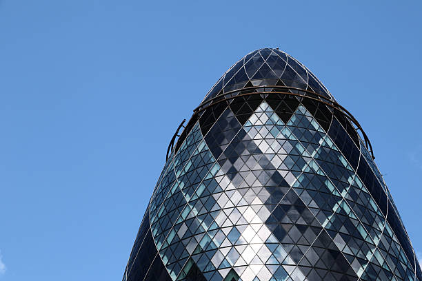 Photograph of The Gherkin (30 St Mary Axe) in London, captured in bright summer daylight. Clear skies and strong natural light highlight the building’s curved glass façade and modern architectural lines. The image showcases the energy and vibrancy of London’s financial district, emphasising one of the city’s most iconic landmarks in crisp, daytime light.