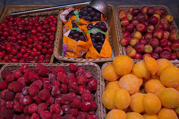 At north of China during winter, street vendors sell frozen fruits and berries for tourists as a snack when strolling around area.