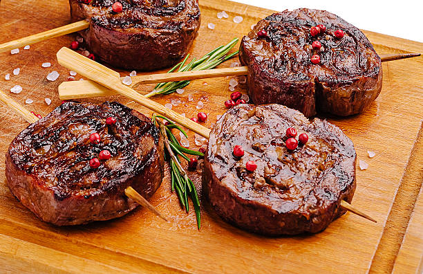 Delicious grilled beef skewers served on a wooden board