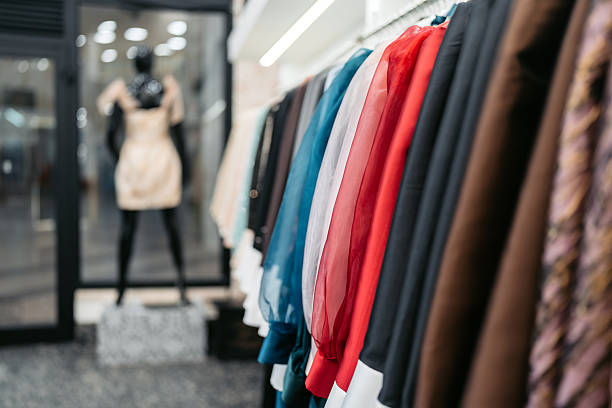 clothing items on hangers in a retail store, with a blurred background showcasing more garments