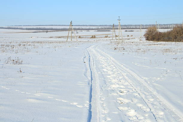 A snowy road with power lines. Snow. Outdoor. Sky. Nature. Covered