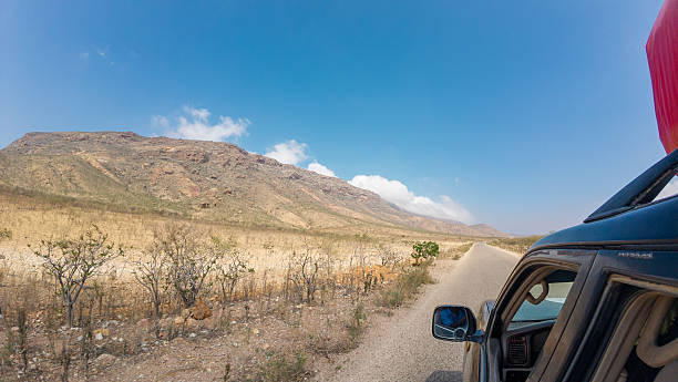 A scenic view of a desert road with mountains in the background.