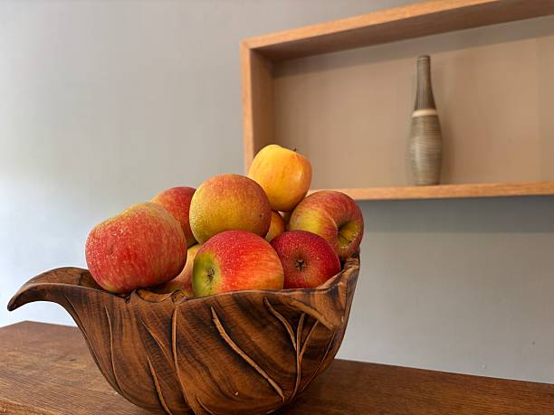 An apple fruit with brown curves caused by worms on the floor.