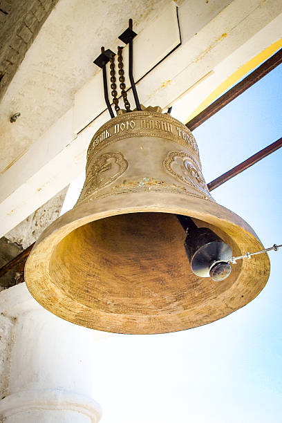 A historic bell in a bell tower with intricate engravings. Architectural style of the Russian Golden Ring towns. For religious, historical, or cultural projects.