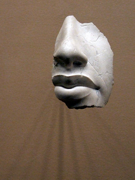 Shard of a statue's face of an Etruscan man. Backlit for effect. New York New York, 2009