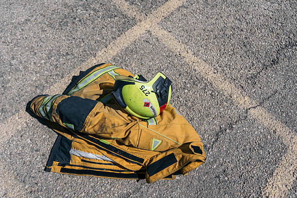 Close-up view of fire truck's open storage compartment revealing organized emergency rescue gear, colorful equipment, and yellow hoses under natural daylight conditions.