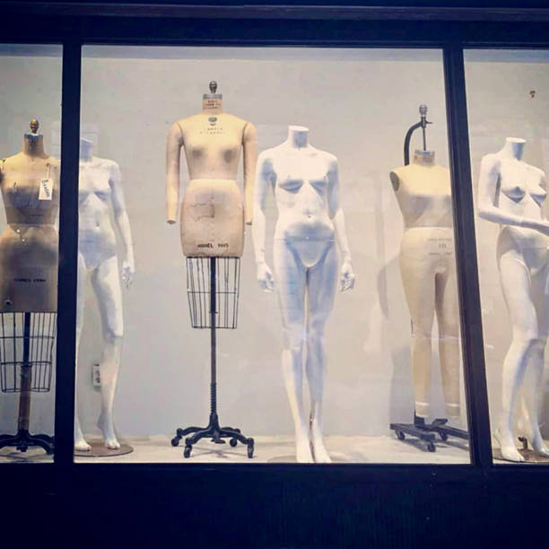 Photographed in New York City, this storefront window features a striking lineup of mannequins and dress forms—some anatomical, some industrial, all headless and poised in quiet formation. Their neutral tones and sculptural presence evoke the legacy of garment-making in the city, while the glass reflection and muted palette suggest urban stillness and creative tension. This image captures the spirit of authentic travel: discovering the unexpected, the artistic, and the deeply local in everyday corners of NYC.
