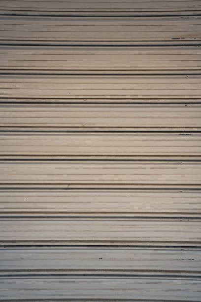 Texture background shows Closed Rolling shutters in front of closed store fronts.
