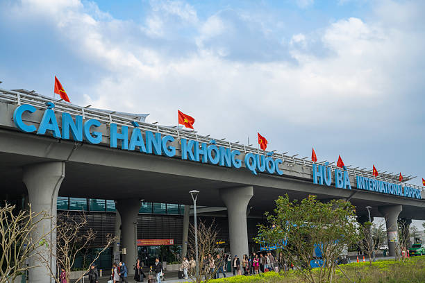 8 January 2026 Hue, Vietnam. Exterior view of a modern airport terminal with Vietnamese national flags, landscaped foreground, and travelers entering the building, illustrating transportation infrastructure and international travel at Phu Bai International Airport in Hue, Vietnam.