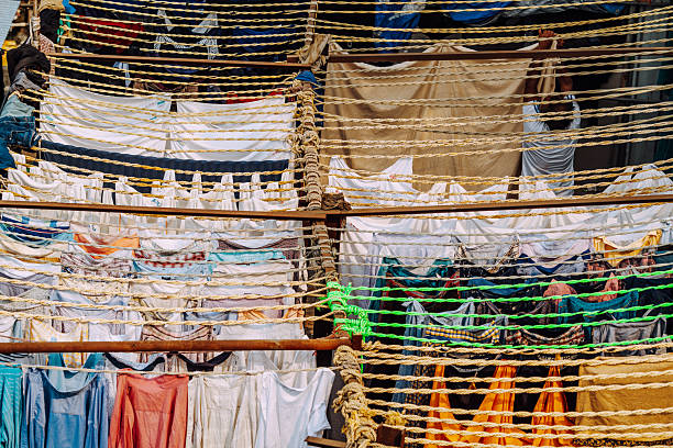 A dense display of clothes drying on multiple strings across a busy Mumbai backdrop, creating a mosaic of colors and textures that evokes urban life and daily routines.