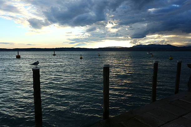 Stunning views of Sirmione and Lake Garda featuring calm waters, medieval castle, and charming village scenes perfect for European travel and landscape stock photography.
