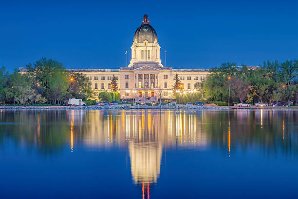 The Saskatchewan Legislative Building and Wascana Lake in downtown Regina Saskatchewan Canada at night.