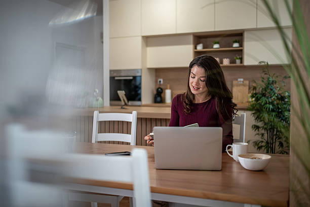 istock Woman working remotely from home kitchen using laptop 2257118527