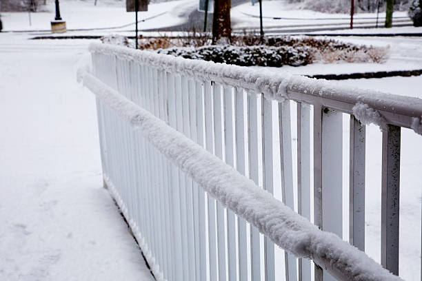 Hand railing covered with snow on a dreary winter day.