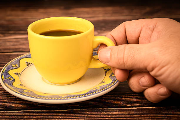 Close up of unrecognizable businessman holding white cup of coffee. Copy space.