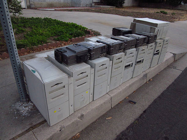 Discarded washing machine among trees, issue of electronic waste.