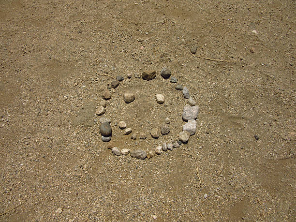 Smiley Face Made of Small Rocks in Dirt