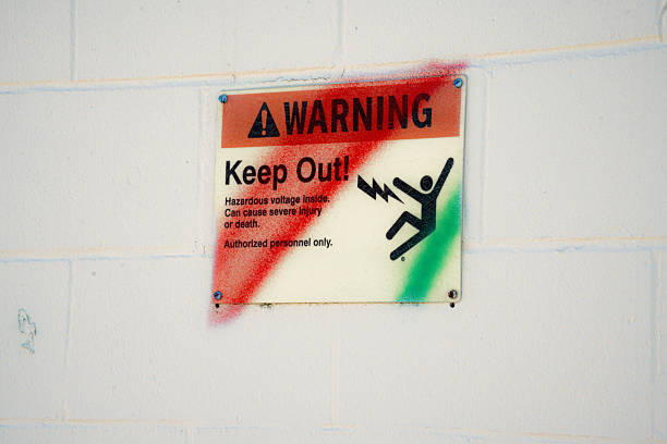 A clear warning sign indicating hazardous voltage and restricting access to authorized personnel only, with a symbol of electric shock