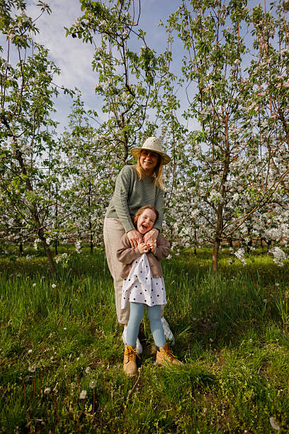 Mother and Daughter Having Fun in Apple Orchard