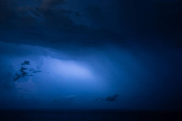 Powerful lightning breaking through dense clouds at night, highlighting the raw energy and intensity of a nighttime thunderstorm