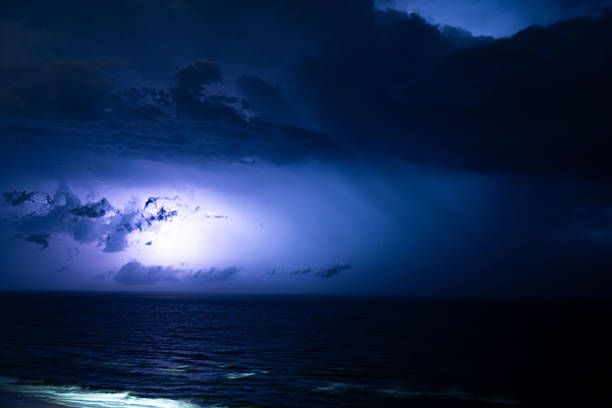 Powerful lightning breaking through dense clouds at night, highlighting the raw energy and intensity of a nighttime thunderstorm