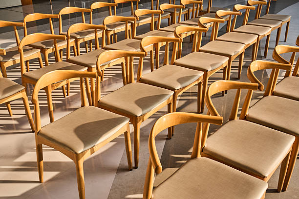 Rows of empty wooden chairs in a meeting room