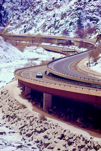 Interstate 70 near Glenwood Springs, Colorado, winds its way through Glenwood Canyon along the Colorado River in winter as snow blankets the ground around it.