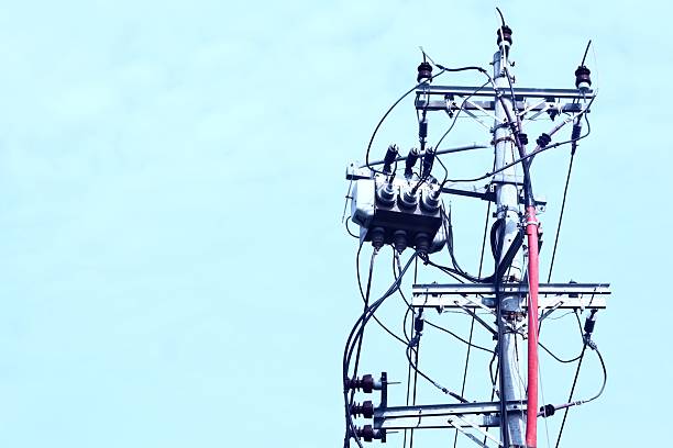 Electricity transformers current supply GEB in India. High voltage transformer against the blue sky. Electric current distribution substation. Transformer station and power lines in village.