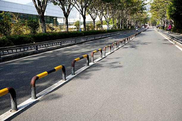 A weathered metal barrier is positioned on a brick-paved path, surrounded by subtle textures and patterns. The scene evokes a feeling of urban neglect and quiet solitude.