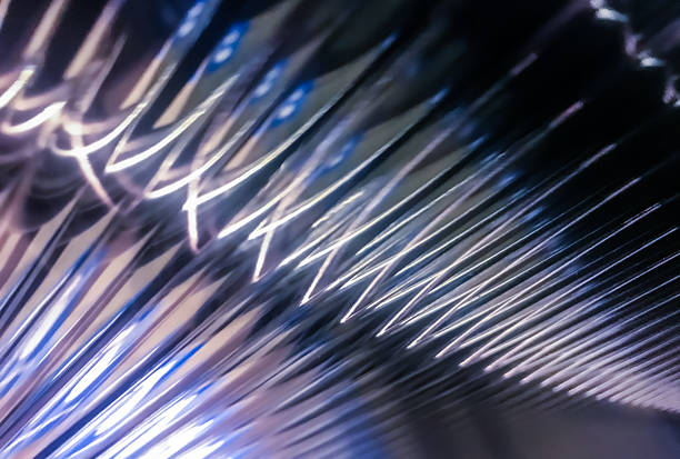 Macro view of shimmering glass surface with repeating patterns and cool blue light, creating a futuristic texture.