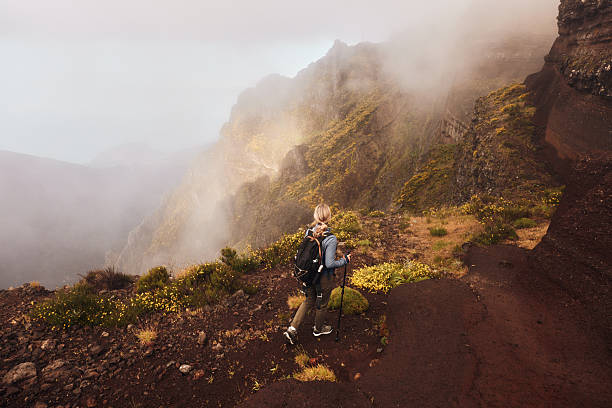Back view of a female backpacker looking at mountain view during her hike. Copy space.