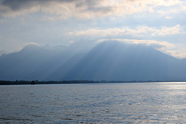 crepuscular rays through clouds over Lake Geneva and apls mountains in Switzerland