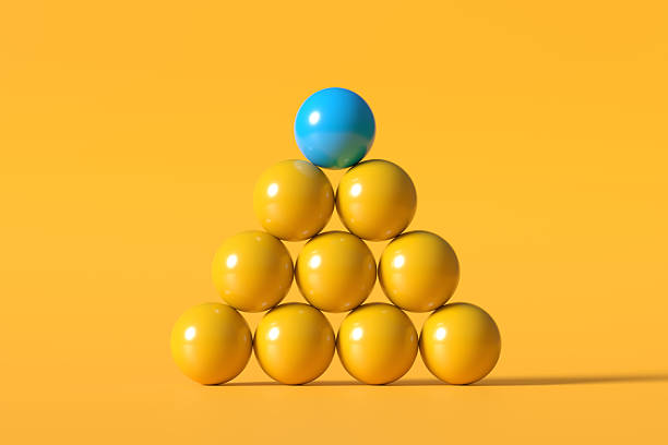 Pyramid of yellow spheres with a blue sphere on top symbolizing leadership, diversity and teamwork