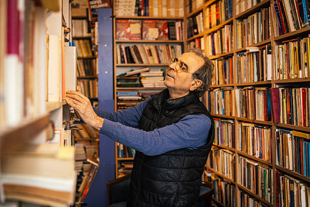 Mid adult man working and reading in his library