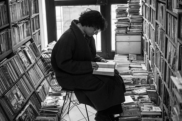 Young Woman Browsing Books in a Library or Bookstore