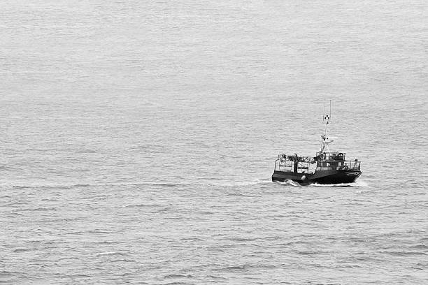 Fishing boat traveling across the vast open ocean, creating a conceptual sense of freedom, solitude, and journey. Santoña, Cantabria