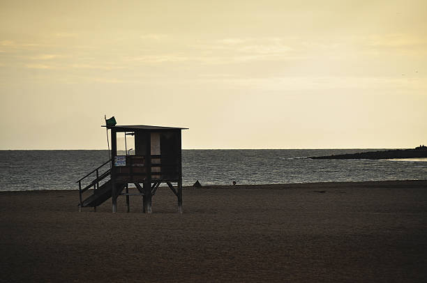 Orange sunset sky over beach lifeguard tower