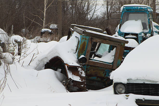 one old plastic part from an old gray drum from a washing machine lies on the ground in white snow on a winter street