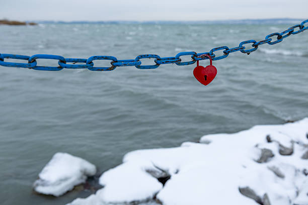 Red paper heart stuck in the chains of disc golf basket.