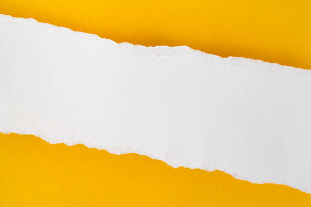 istock uneven torn blank white paper on grunge yellow paper, top view 2257187083