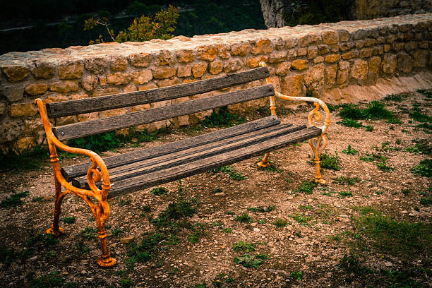 Empty old and rusty park bench outdoor during the day