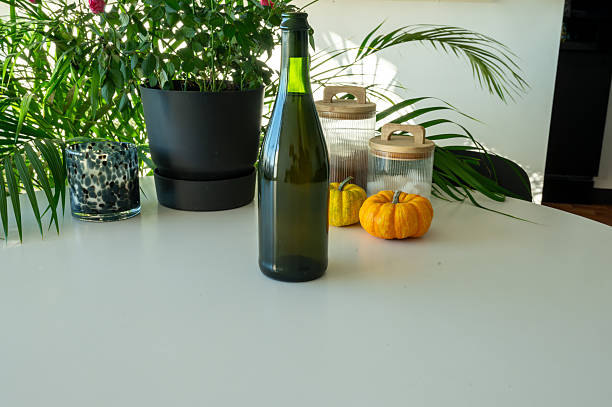 Bottle of wine on the table in the bright kitchen with pumkins and other dishes