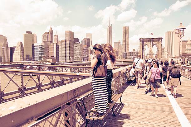 People walk across famous Brooklyn Bridge in New York. Almost 19 million people live in New York City metropolitan area.