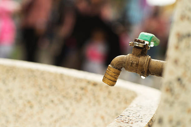 Brass Faucet with Water Droplet in Outdoor Setting
