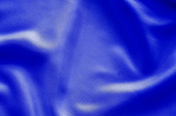 Deep blue fabric texture with dramatic folds and rich lighting for abstract and creative backgrounds